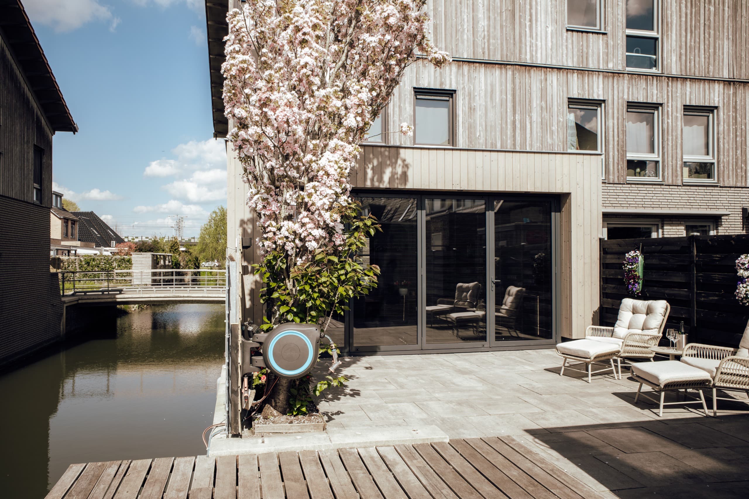 Terras aan het water met een houten prefab aanbouw van AddOn