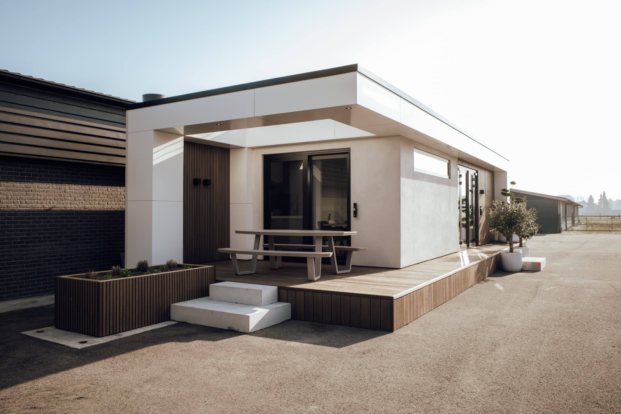 Brede foto van een moderne prefab aanbouw met terras