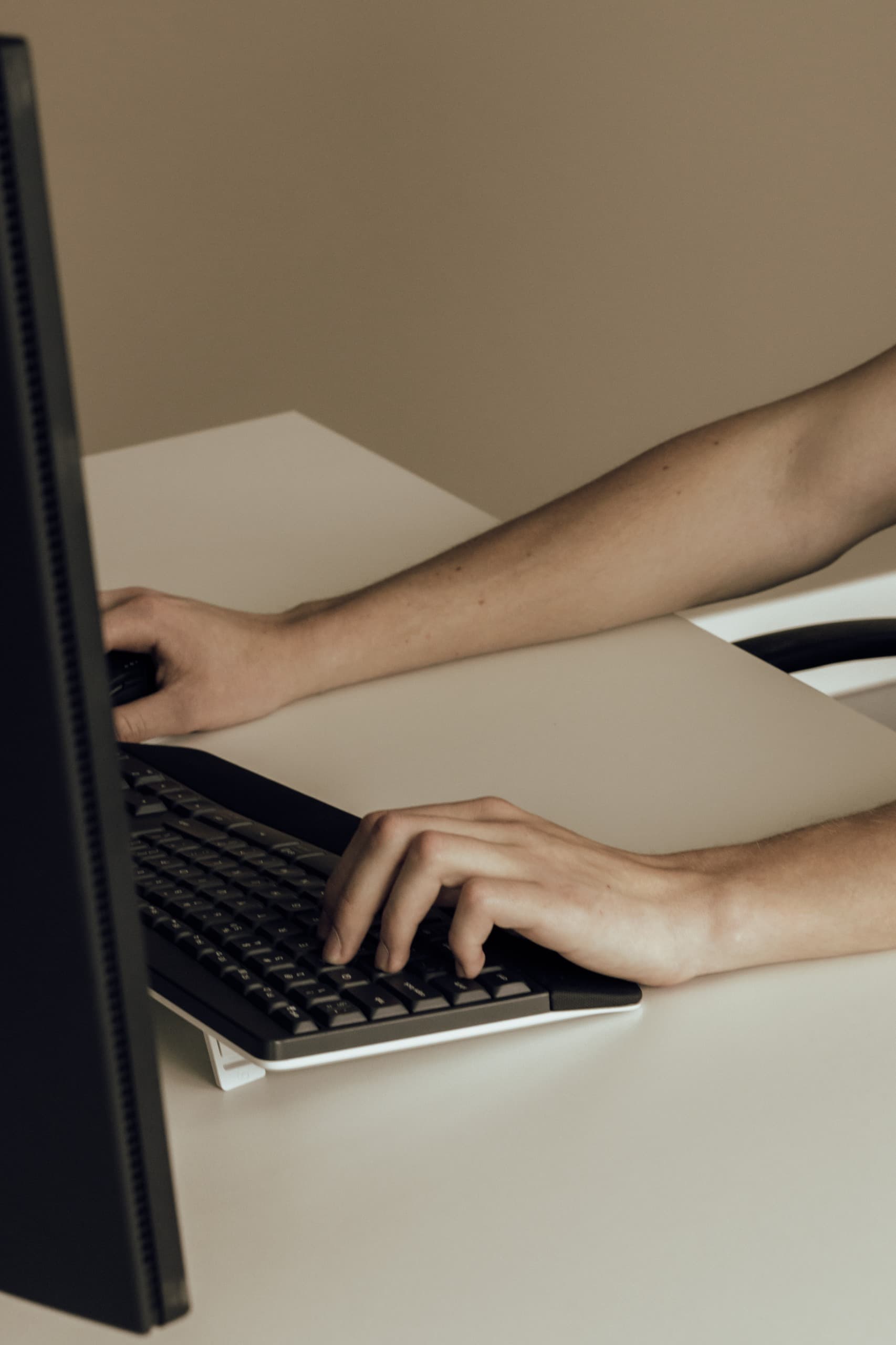 Handen die administratief werk verwerken achter een computer